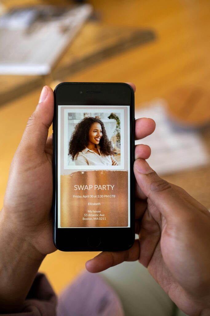 Close-up of hands holding smartphone displaying a swap party invitation.